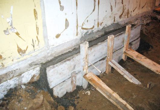 As we filled in adjacent sections, we tied the rebar together to create a continuous monolithic footing. Since we had to chip away part of the old footing to gain access for pouring the concrete, we formed the new footing to maintain the original 20-inch footing width.