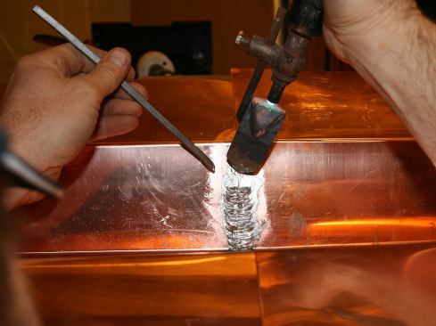 For vertical seam work, the temperature needs to be just right: if the iron is too hot, the solder starts running away too quickly off the tip; and if the iron is too cold, it won’t get sucked back underneath the top piece, weakening the weld. Also, this where having a sharp tip really pays off. Starting at the bottom…