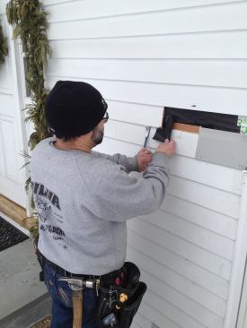 A tab of tar paper inserts behind the butt joint of the clapboard before the new piece goes in.