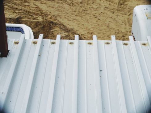 The panels are either screwed or (as shown above) puddle-welded to the steel frame.