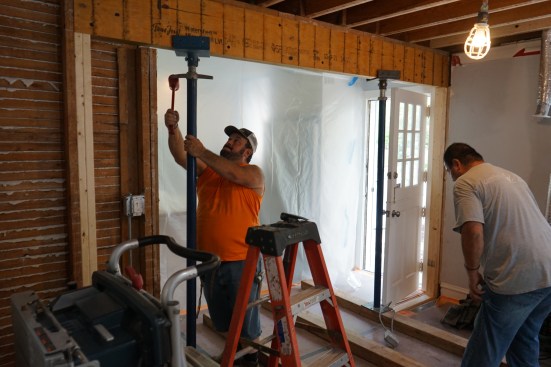 Undermount beam. It extends beyond the corner so the end column (new framing in foreground) bears directly on the new basement beam.
