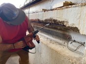 Repair work began by chipping out the unstable concrete around corroded reinforcing steel.  They needed to remove enough material so that new mortar could fully encase the existing rebar.