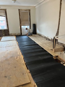 By rolling it out over plywood, a crew member was able slide it into position.