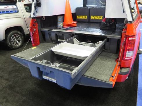 The DECKED Truck Bed Storage System fits in the bed of a pickup. Made from high density polyethylene (HDPE) the unit can support 2,000 pounds on the deck. Available for 5’6” and 6’6” beds, it has two 4’ drawers—each rated to carry 200 pounds. The drawers ride on rollers and are secured by heavy spring-loaded latches. If the tailgate doesn’t lock there’s the option to equip the drawers with keyed cylinders. The unit is 12” tall and is held in place using existing hold-downs; there’s no need to drill any holes in the bed. The DECKED storage system is available for multiple makes and models of vehicles.
Click here for video.
