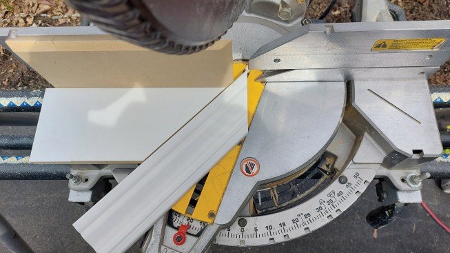 A site-built jig to cut angles above 45 degrees is affixed to the saw fence.