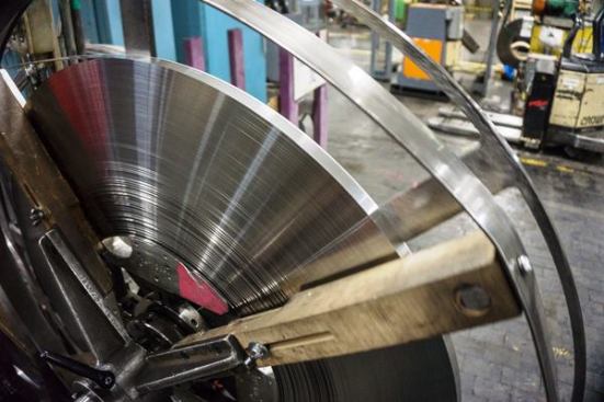 The steel gets coiled again as it comes off of the welder. It is then transported to the next operation, the tooth cutting machine.