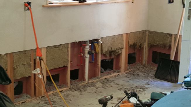 Another look at the wall after demo during flood remediation work. Drywall and Roxul rock wool insulation have been removed, holes have been cut in the OSB air control layer, and damp insulation has been pulled out of the outside cavity of the double insulated wall system.