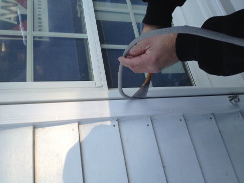 To seal between the window and the trim, Manny first presses foam backer rod into the joint.
