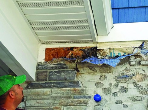 Water from above was being injected onto the top edge of the frieze board that divided the vinyl and manufactured-stone sections of the wall.