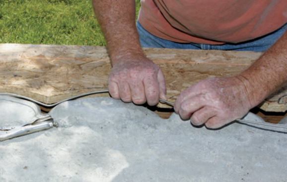 I bent 9-gauge (1/8-inch-diameter) stainless steel rod to reinforce the undulating edge of the mortar bed, placing it about an inch in from the perimeter and following the shape outlined by the marker.