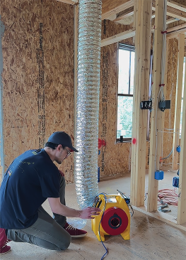 Retrotec’s Noah Lawrence assists with pre-drywall duct testing. This initial test proved the ducts were too leaky, prompting the crew to chase down more leaks to meet the ZERH standard.