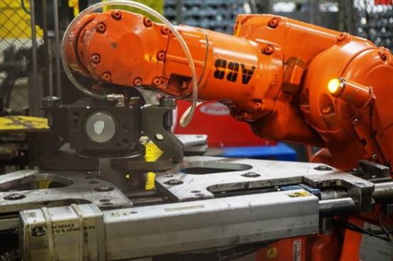 The robot grabs a plate & inserts it into the coiled blade. Another robot grabs the infant hole saw and brings it to the welding robot.The robot grabs a plate & inserts it into the coiled blade. Another robot grabs the infant hole saw and brings it to the welding robot.