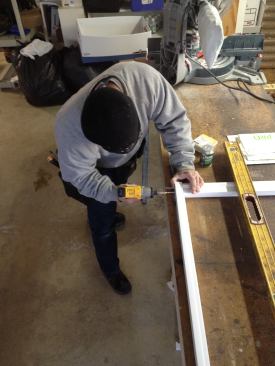 Manny glues and screws the sill piece to the brickmold trim.