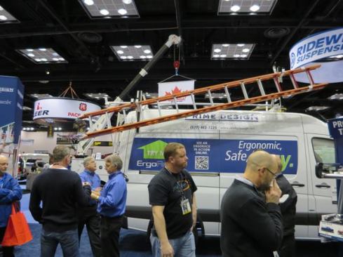 A variety of ErgoRack ladder racks were being shown on vans. This one is on a very tall Sprinter and the fellow in back is in the process of bringing the ladder down. The rear end of the ladder swings farther down and can be brought lower still by pulling on a slide mechanism. The ladder can be lifted off of the rear bracket and then off of the front.
Click here for video of how the rack works.