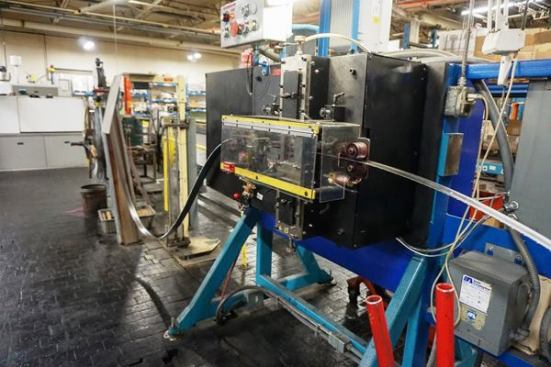 This is one of the machines Lenox uses to set teeth; it can set about 4 inches of teeth at a time. The strip goes in flat and comes out with the teeth set to the correct kerf width.