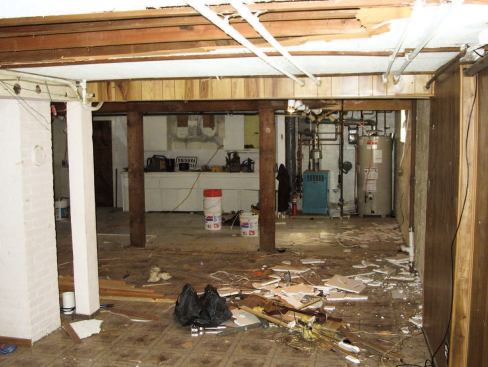 In the original basement, a low-ceilinged family room shared space at the front of the house with a large utility area.