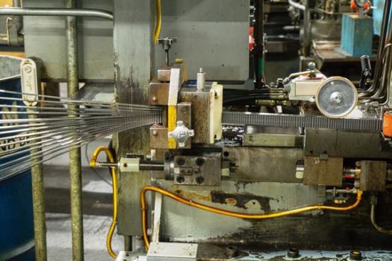 After the teeth are cut into them the bimetal strips exit the machine and rolled into individual coils.