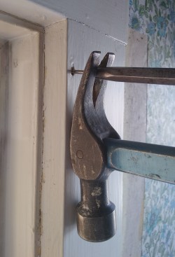 Often it just needs to be loosened, after which it can be pulled out by hand.  If the nail is small enough, though, you will be driving the pin through fresh wood and it will need to be pried all the way out. In this case, use a block under the hammer to keep from bending the pin and to protect the face of the board.