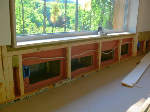 Open wall cavities under a window during flood damage restoration work. The double wall cavities had to be exposed and dried out using heaters and dehumidification equipment.