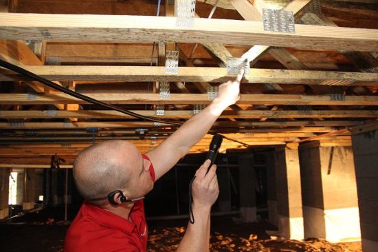 Energy One America operations manager Seth Harris points out surface mildew on the floor trusses in a new house during a crawlspace sealing and conditioning job. In the South Carolina climate, mold tends to grow quickly, even in a very well-ventilated crawlspace — a strong reason to prefer a sealed, conditioned crawl. (Atmospheric humidity, not wood moisture content, is the culprit: Harris measured the moisture content of the trusses at only 16%.) Once this crawlspace is airtight and vapor-tight, and with mechanical dehumidification operating, Energy One will return to scrub away the mildew with a sanitizing cleanser. Given dry conditions, the problem should not re-occur.