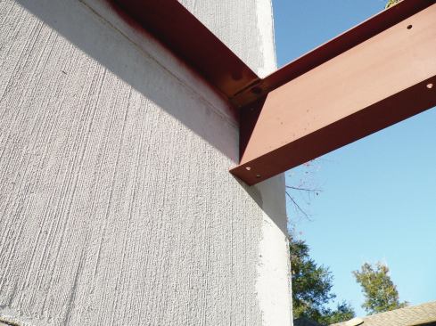 The side I-beams are welded to a 5x5 angle ledger that has been through-bolted to the house.