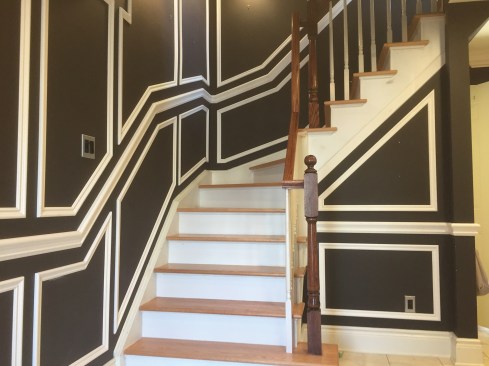 Applied molding can look complicated, especially with a high-contrast palette, but most of the layout here was created using a 3-inch block along the chair rail, baseboard, and ceiling. Then we filled in the vertical lines at the desired spacing.