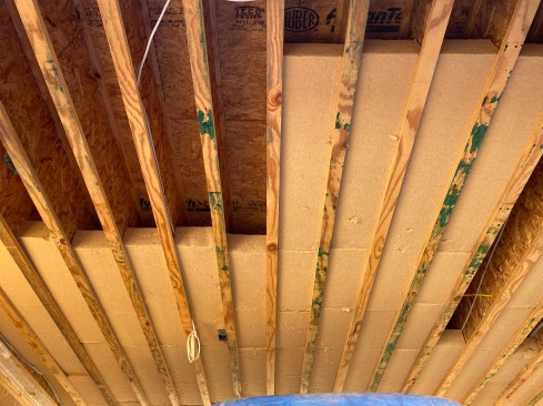 The author opted to establish the thermal boundary in the lower part of the floor to avoid the large number of electrical and plumbing obstructions in the upper half of much of the floor diaphragm.