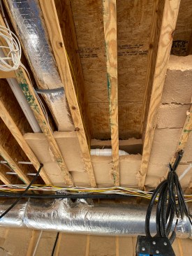 The author's crew fit batts around the electrical and plumbing obstructions in the much of the floor cavity.