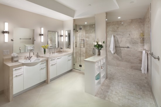 This bathroom also includes adaptable features, such as undersink cabinetry that can be easily removed to provide clearance for a person in a wheelchair, as shown in the image below.