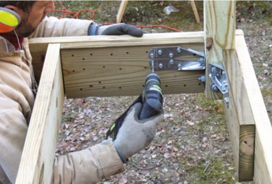 Most manufactured railing systems require posts mounted inside the rim. That requires both a bracket to resist the outward force at the top of the rim, and blocking to resist the inward force at the bottom of the post.