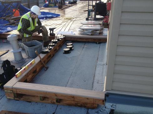 Bison Versadjust pedestals can be used to support conventional wood framing, though in the photo, they are being used to support large-format tile.