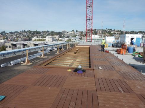The pedestal-supported deck grids wrap around a 120-square-foot bocce court. Steel stanchions for the railing system (to the right of the deck) were installed before the torch-down roofing.