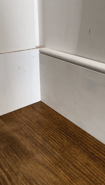 The trimmed baseboard meets the plinth block as intended with a clean line at the floor.