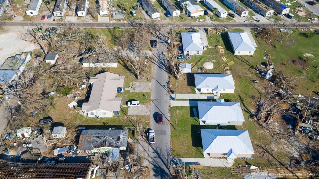 In this aerial view, five "Habitat Strong" houses look pristine in a neighborhood ravaged by Hurricane Michael's winds. The houses have beefed-up roof details and a continuous engineered load path.