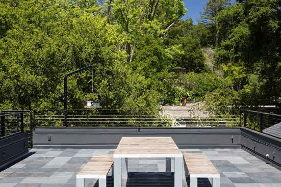The rooftop patio provides the family of five a place to gather outside and enjoy the woodsy landscape while maintaining privacy.