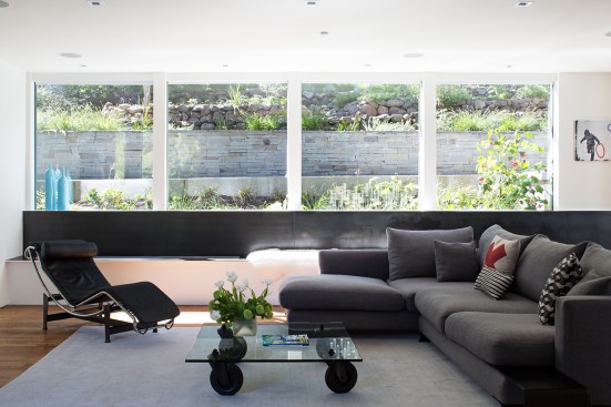 The remodeled family room features a multi-functional bench that helps to hide from view the retaining wall outside the window. It also houses an ethanol-burning fireplace that provides ambient light in the evening.