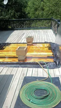 When building curved railings, the author soaks 1x4 cedar rail stock in a temporary pool made with 2x4s and a sheet of black plastic.