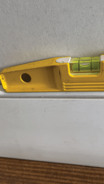 With the baseboard set level, tack the baseboard in place to prepare to scribe. 