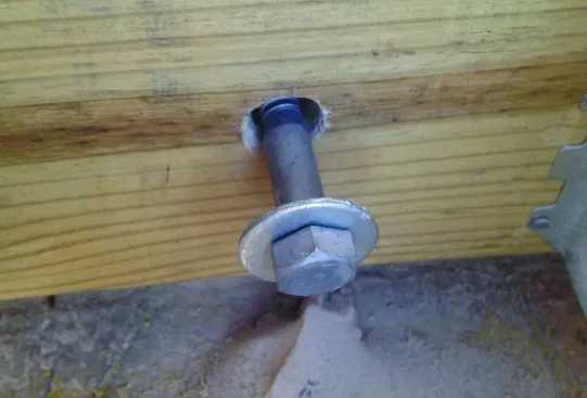 Oversized holes had to be bored through the brick veneer so that the ledger bolts wouldn’t bear on the brick.