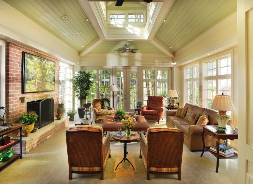 During the day, light floods into the addition through the walls of windows and cupola.A masonry fireplace ensures the room can be used in cold weather as well.