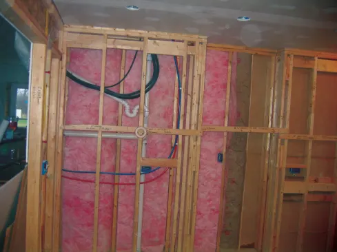The flexible condensate drain is run inside a diagonal 1 1/2-inch PVC pipe that empties into the DWV line. Note the P trap. Slack in the line set and wire allows maintenance or repair of the head without crimping the copper tubing.