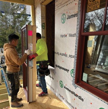 The crew installs low-E, argon-filled double-pane windows.