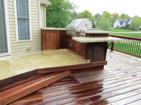 Angles make a space appear larger and more dynamic and can be used to create a nook that doesn’t interfere with traffic flow. Note that the deck and patio surfaces have been “flip-flopped” on this project, which features a travertine terrace on the top tier, and cumaru decking below. The Brentwood stone countertops look like petrified wood, tying it all together. 