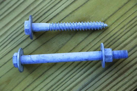 Hex-head 1/2-inch hot-dipped galvanized bolts and 1/2-inch lag screws with standard cut washers are the only two fastener options listed in the IRC for attaching deck ledgers.