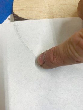A darkened finger tip run along the edge of the wood on the paper creates a crease and an easy-to-see line. Cutting along this line will make a template.