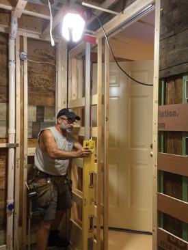 He carefully checked that the jambs were square to the header and plumb before screwing the frame to the floor.