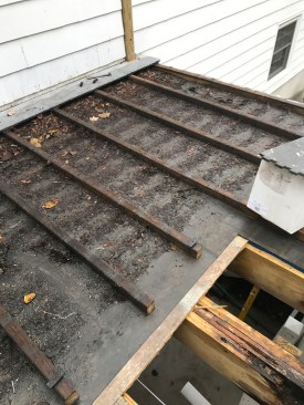 Water had seeped down into the triple support beam below the posts, causing significant rot. Note all the dirt and debris that had collected underneath the decking between the sleepers.