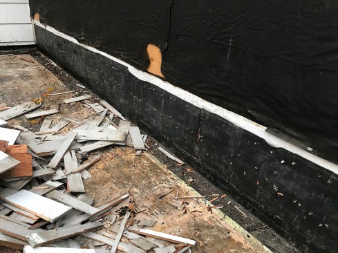 The porch deck-to-wall flashing was reverse-lapped over the WRB underneath the wall shingles, creating a potential pathway for water to penetrate the structure.