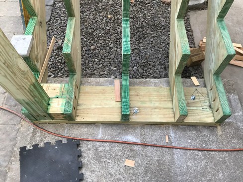 The lower stair stringers are pocket-screwed to a 2x10 that's wedge-bolted to the concrete-slab landing. Solid blocking reinforces the guard-post connection.