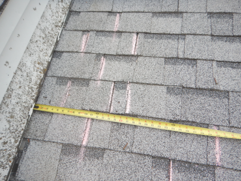 Shingle layout. The chalk lines above show the joints between the shingles. To prevent water leaking into the gap, shingle makers typically require a minimum 4-inch overlap.